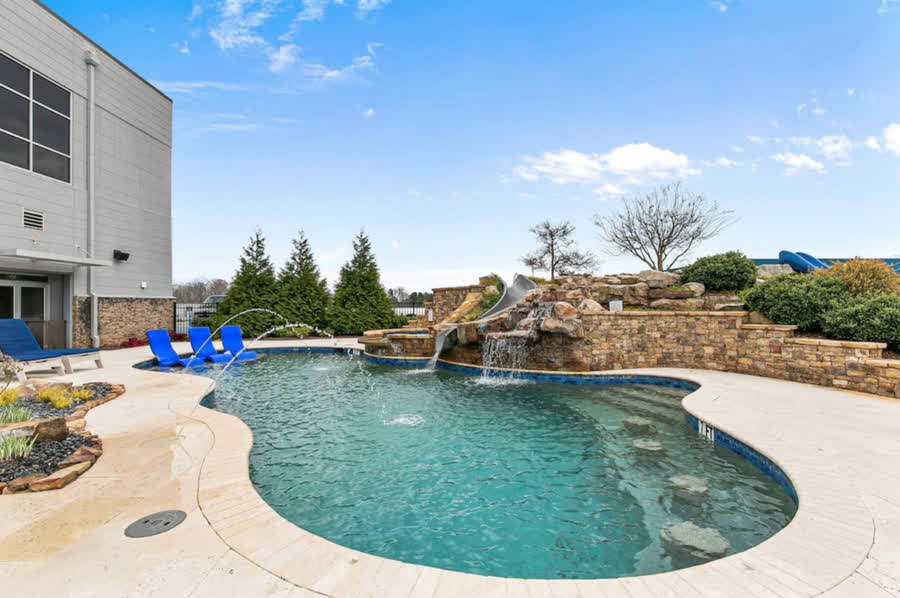 The clubhouse pool at Atlanta Motorsports Park, a rock waterfall and slide at one end and loungers set in the shallow water