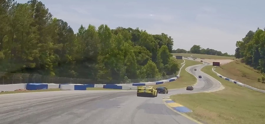 Several cars strung out through the esses at Michelin Raceway Road Atlanta, the circuit falling away and climbing out again beyond